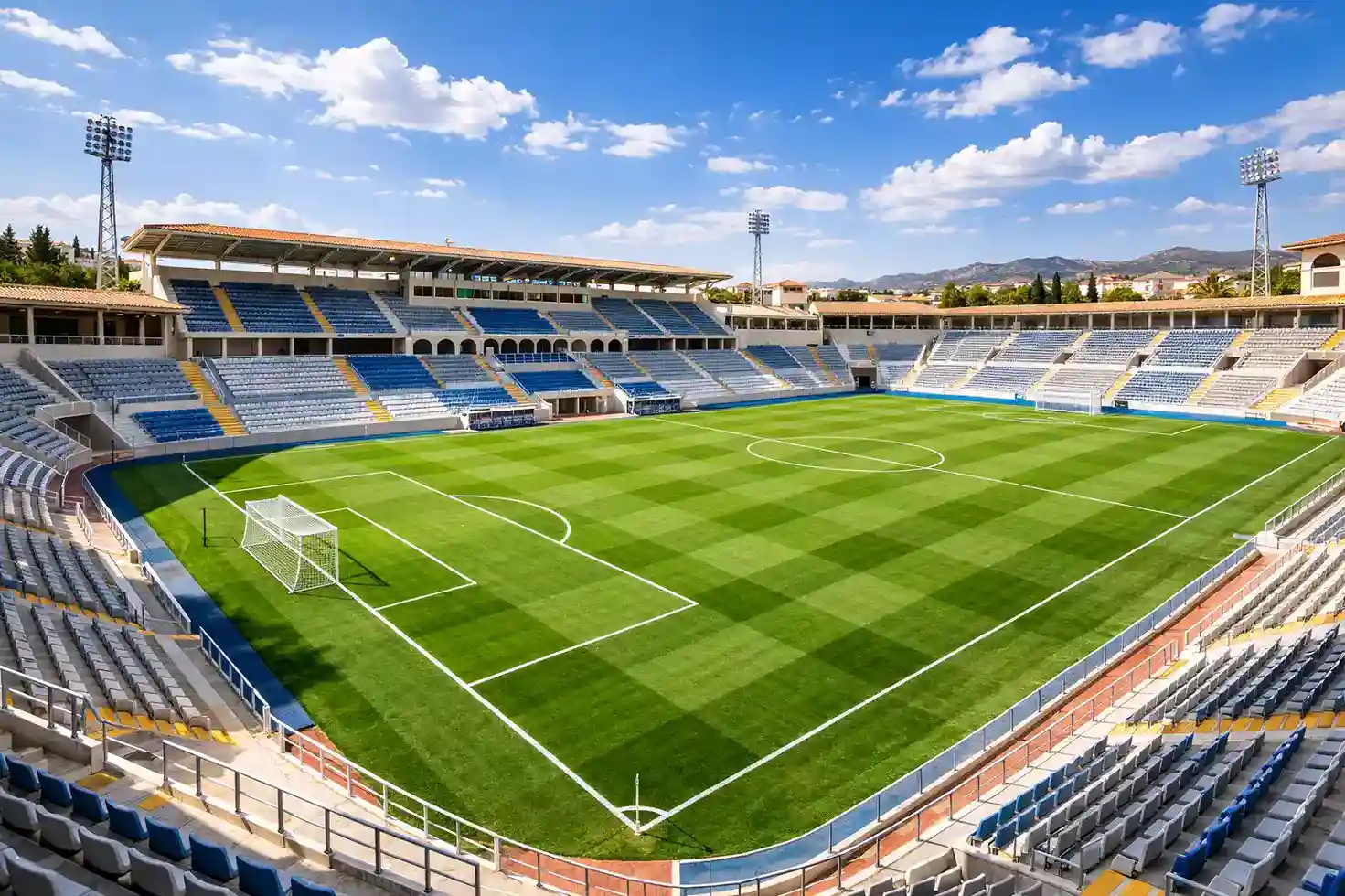 Panorámica de un estadio de fútbol español con el césped iluminado bajo un cielo azul